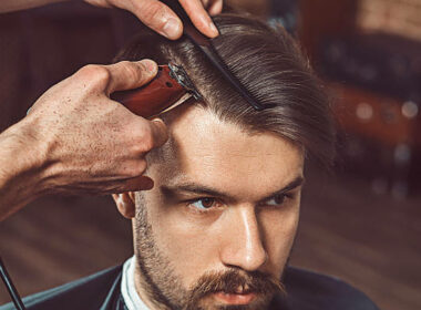 Is $100 Too Much for a Haircut? Hipster client visiting barber shop. The hands of young barber making the cut of beard